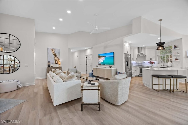 living room featuring ceiling fan, light hardwood / wood-style flooring, and sink