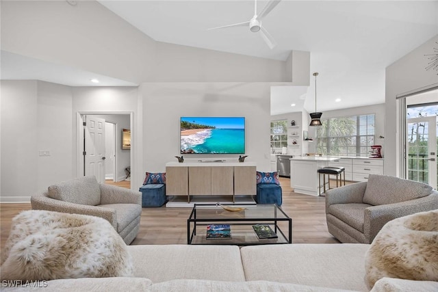 living room featuring ceiling fan, light wood-type flooring, and high vaulted ceiling