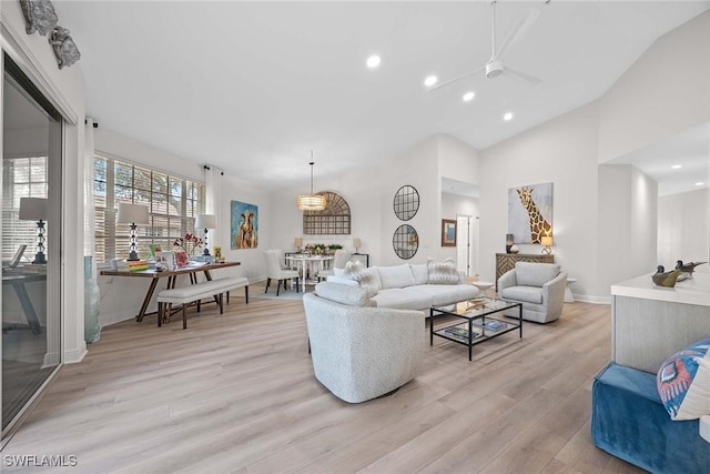 living room featuring light hardwood / wood-style floors, vaulted ceiling, and ceiling fan