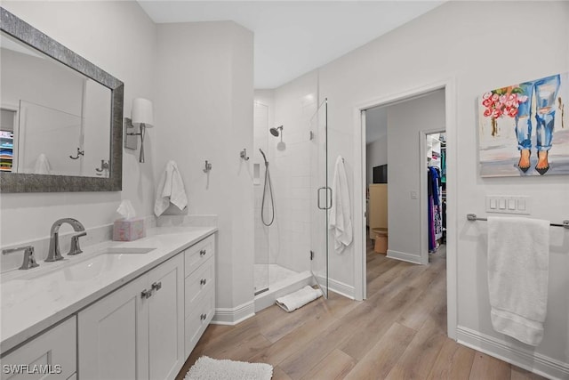 bathroom featuring hardwood / wood-style floors, vanity, and a shower with shower door