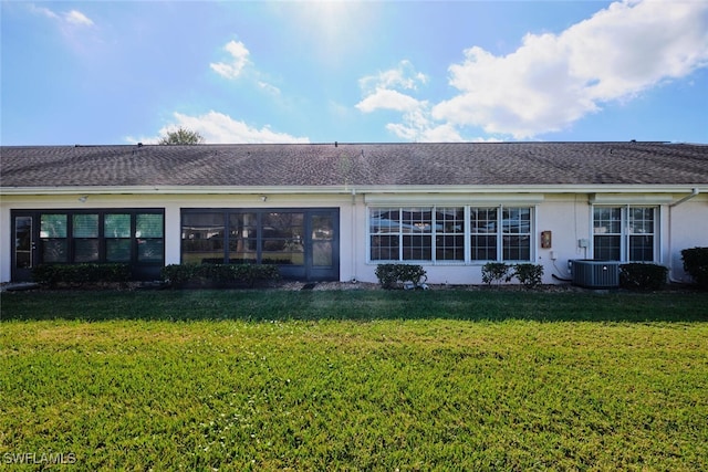 rear view of house with a yard and central AC