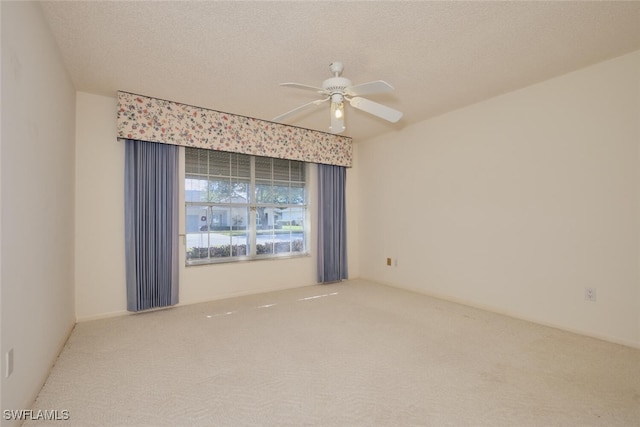 carpeted spare room with a textured ceiling and ceiling fan