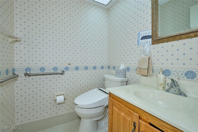 bathroom with tile patterned flooring, vanity, and toilet