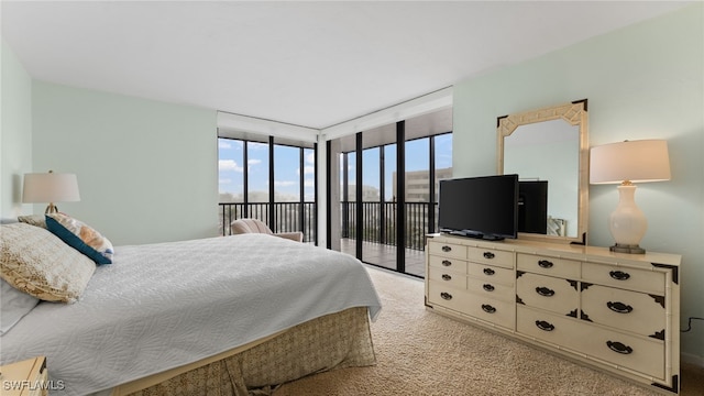 carpeted bedroom featuring access to outside and a wall of windows