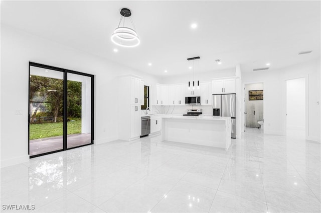 kitchen featuring white cabinets, pendant lighting, a center island, and stainless steel appliances