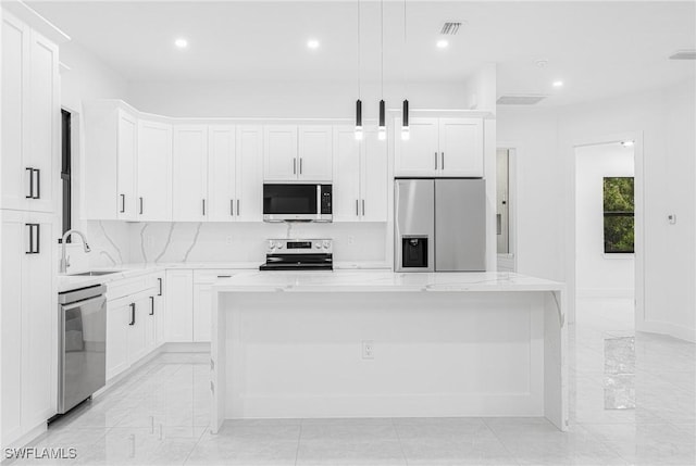 kitchen featuring a center island, appliances with stainless steel finishes, sink, decorative light fixtures, and white cabinets