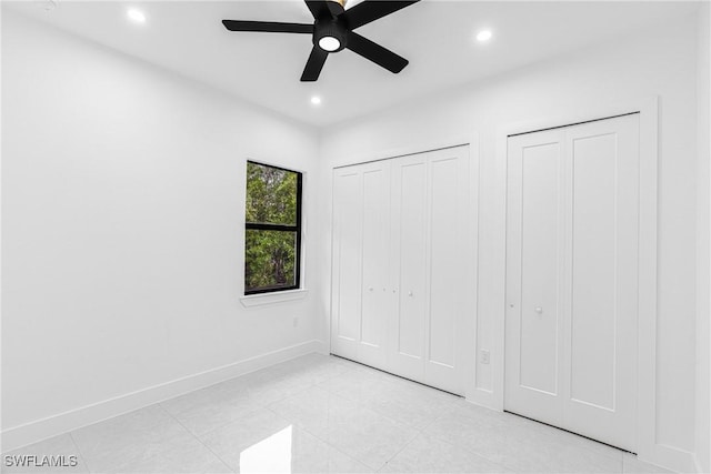 unfurnished bedroom featuring multiple closets and ceiling fan