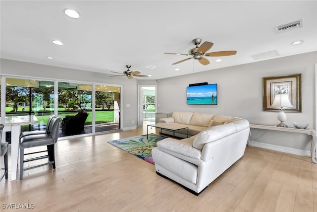 living room featuring ceiling fan and light wood-type flooring