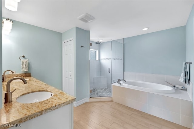 bathroom with wood-type flooring, vanity, and independent shower and bath