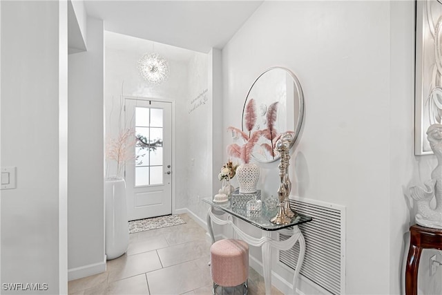 tiled entrance foyer with an inviting chandelier