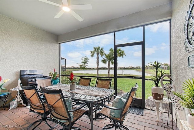 sunroom / solarium with a water view and ceiling fan