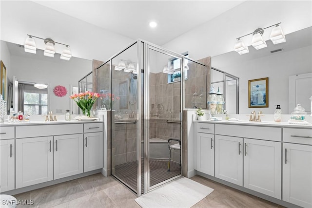 bathroom with tile patterned floors, vanity, and an enclosed shower