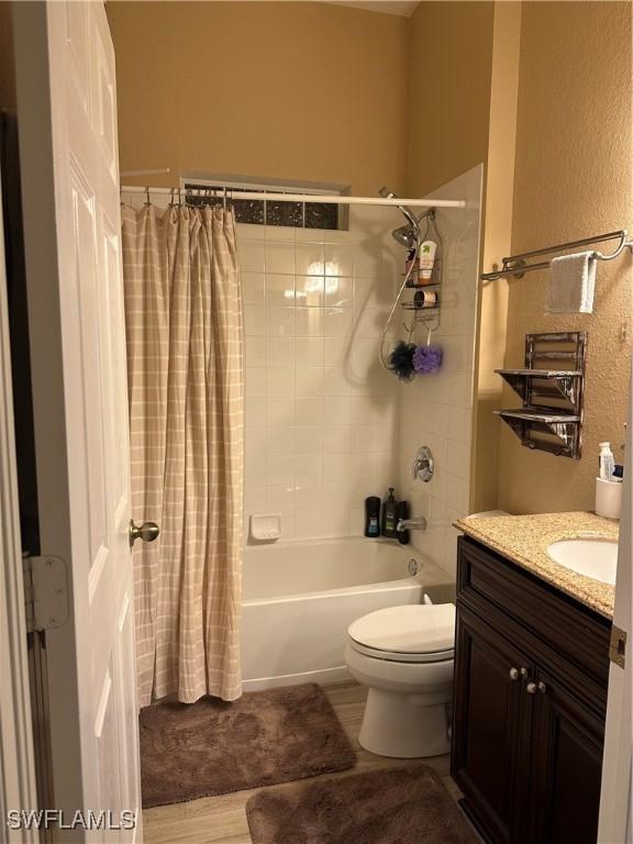 full bathroom featuring vanity, shower / bath combination with curtain, and toilet