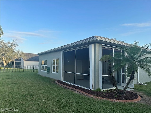 view of home's exterior featuring a lawn and a sunroom