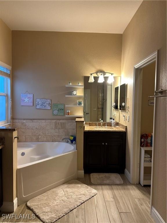 bathroom with a tub to relax in and vanity