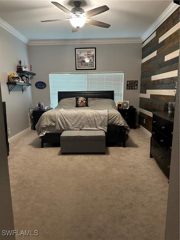 carpeted bedroom with ceiling fan and ornamental molding