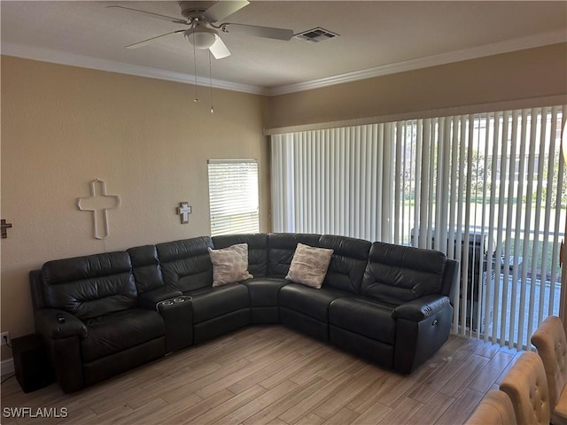 living room featuring a wealth of natural light, ceiling fan, ornamental molding, and light wood-type flooring