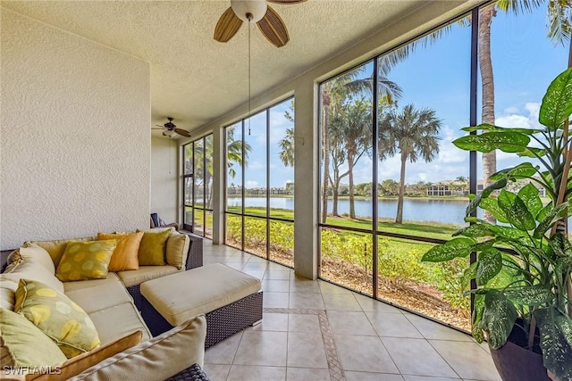 sunroom / solarium with ceiling fan and a water view