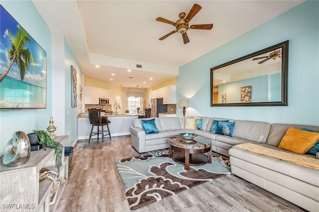 living room with ceiling fan and light hardwood / wood-style floors