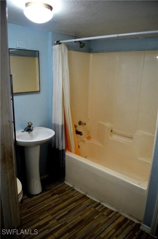 bathroom with hardwood / wood-style flooring, sink, a textured ceiling, and shower / bath combo