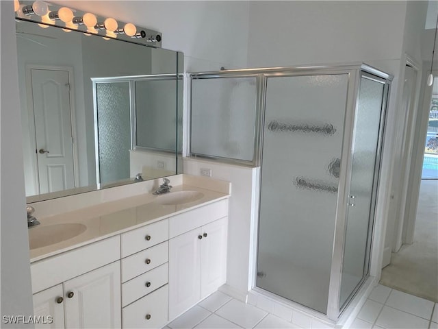 bathroom featuring a shower with door, vanity, and tile patterned flooring