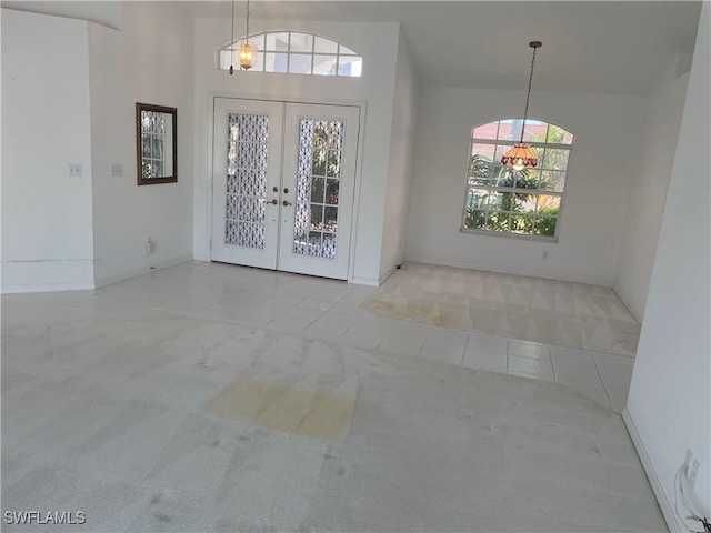 carpeted foyer featuring french doors