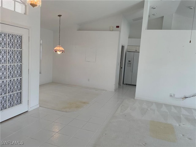 tiled spare room featuring high vaulted ceiling