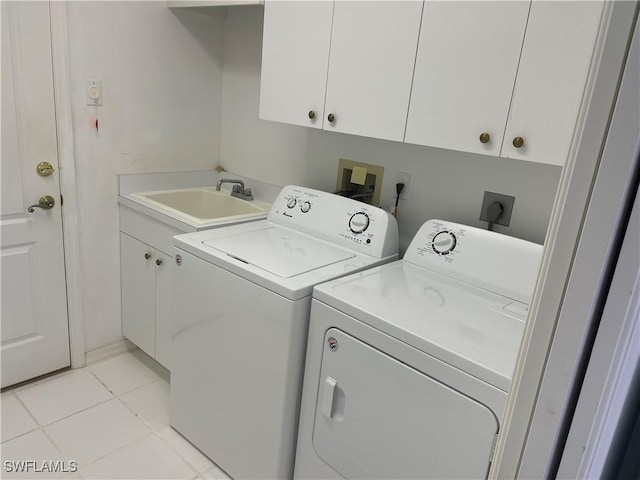 laundry room featuring light tile patterned floors, cabinets, washer and dryer, and sink