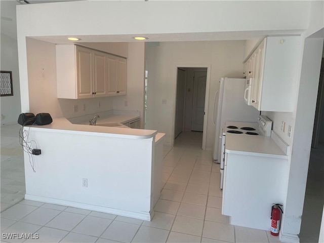 kitchen featuring white appliances, white cabinetry, sink, kitchen peninsula, and light tile patterned floors