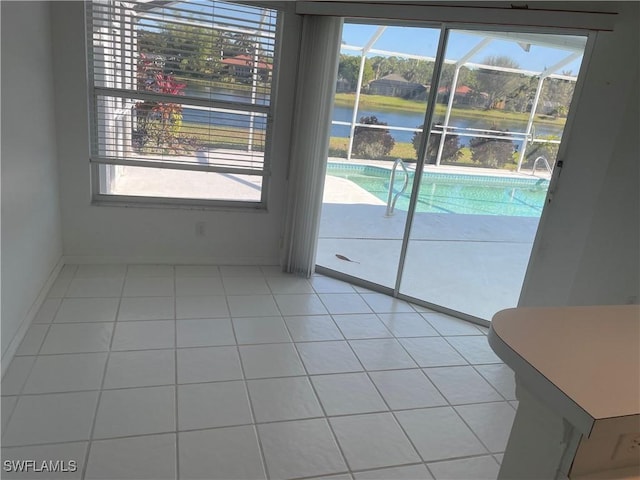 interior space with light tile patterned floors and a water view