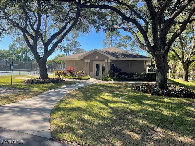 ranch-style home with a front yard and french doors