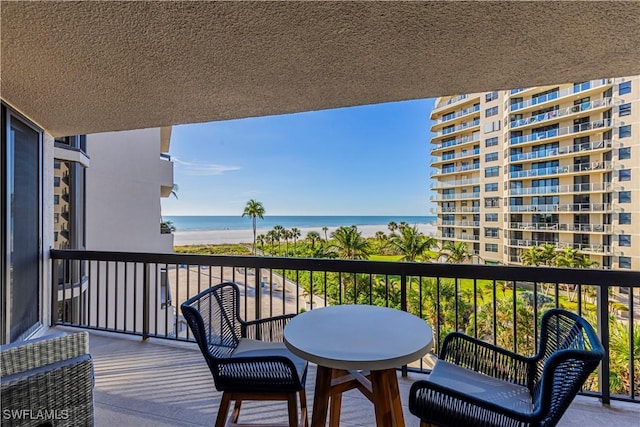 balcony with a water view and a beach view