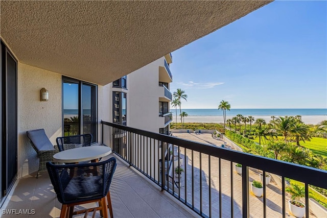 balcony featuring a water view and a view of the beach