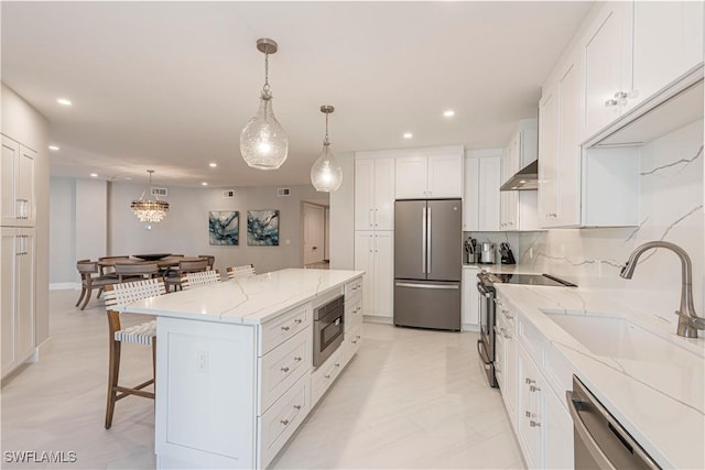 kitchen with white cabinets, a center island, sink, and stainless steel appliances