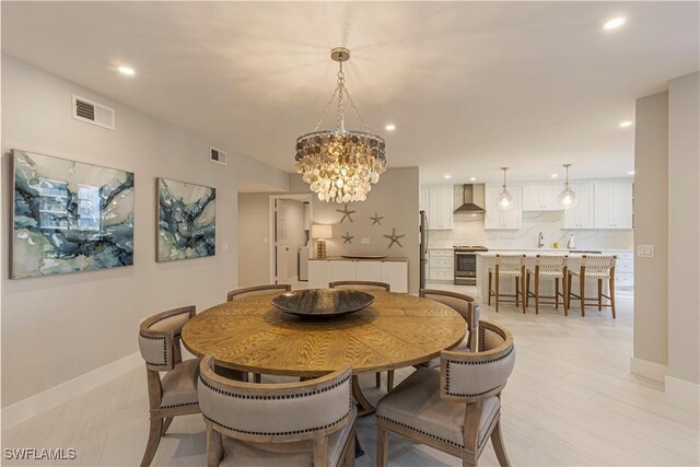 dining space featuring sink and an inviting chandelier