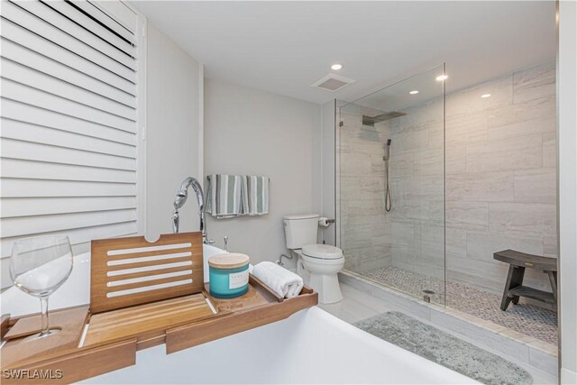 bathroom with tiled shower and toilet