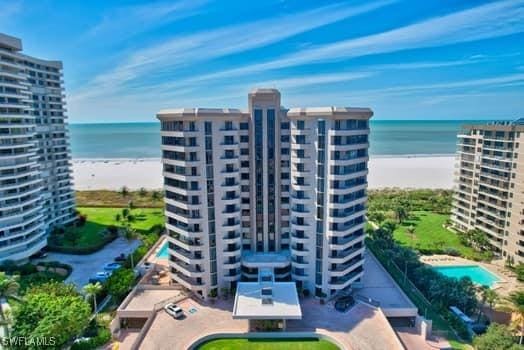 view of property with a beach view and a water view