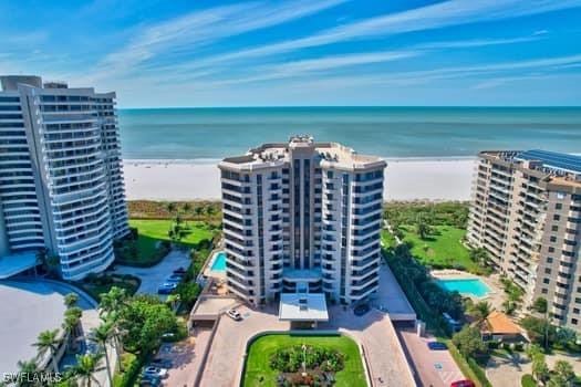 drone / aerial view featuring a beach view and a water view