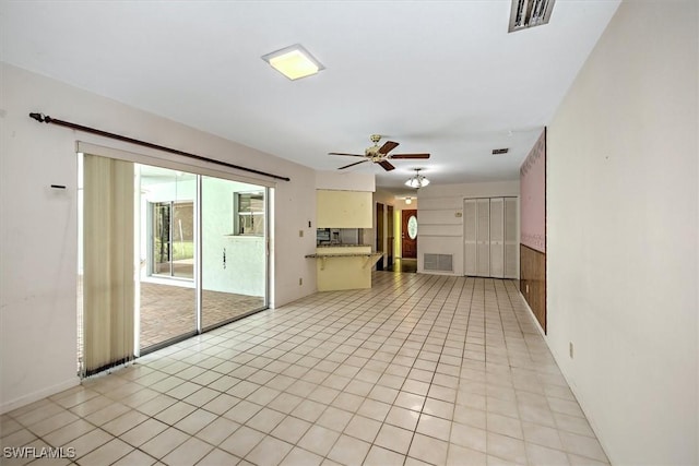 unfurnished living room featuring ceiling fan and light tile patterned floors