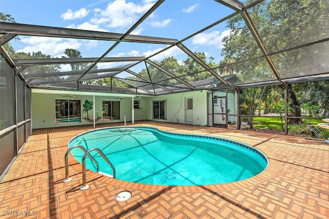 view of swimming pool with ceiling fan, a lanai, and a patio