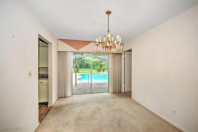 empty room with an inviting chandelier and light colored carpet