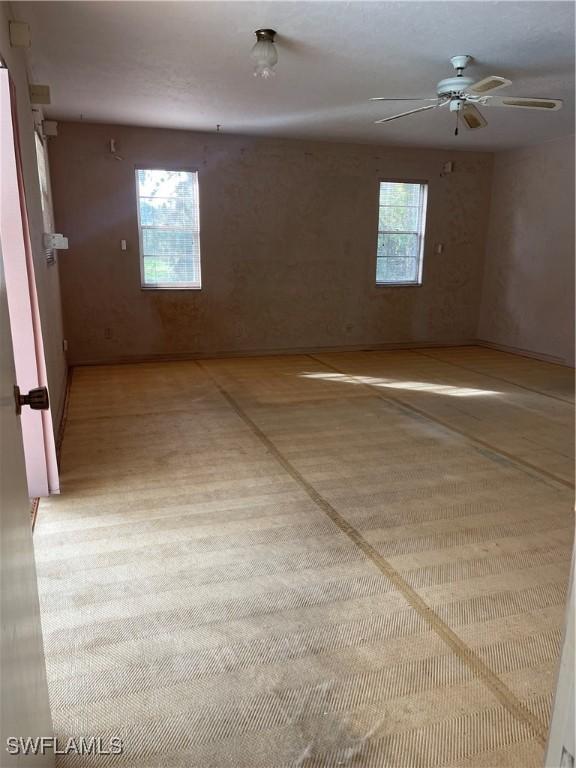 empty room featuring plenty of natural light and ceiling fan