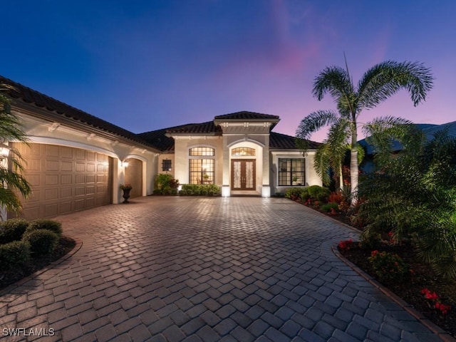 mediterranean / spanish-style house with french doors and a garage