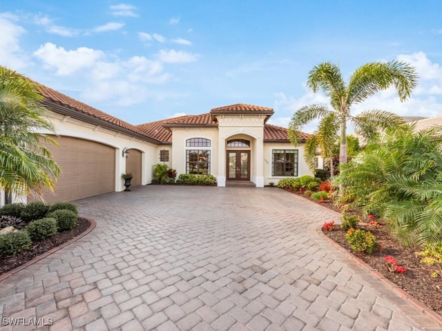 mediterranean / spanish-style home featuring a garage and french doors