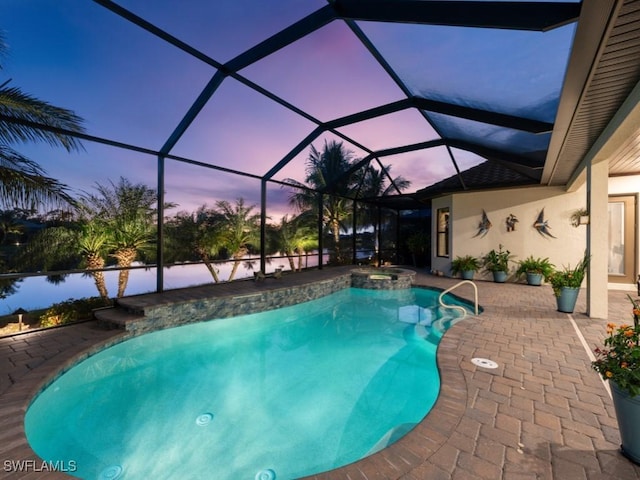 pool at dusk featuring an in ground hot tub, a lanai, and a patio area