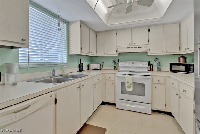 kitchen with white appliances, sink, ceiling fan, light tile patterned floors, and a tray ceiling