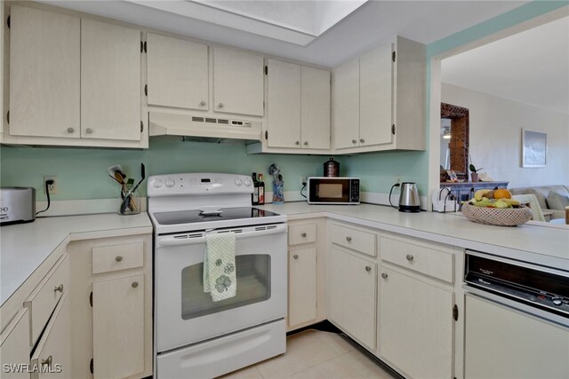 kitchen with electric stove, cream cabinets, and light tile patterned floors