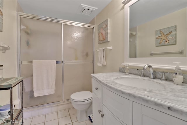 bathroom with toilet, vanity, tile patterned floors, and walk in shower