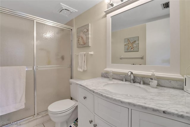 bathroom featuring tile patterned flooring, vanity, toilet, and an enclosed shower