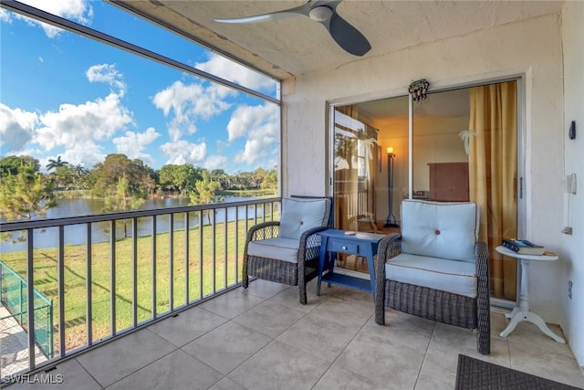 balcony featuring a water view and ceiling fan